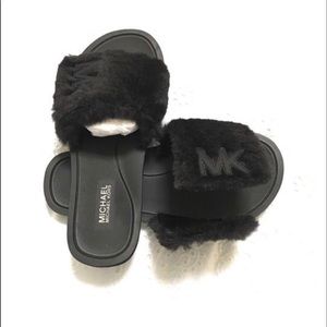 A pair of MK open toe faux fur slides.